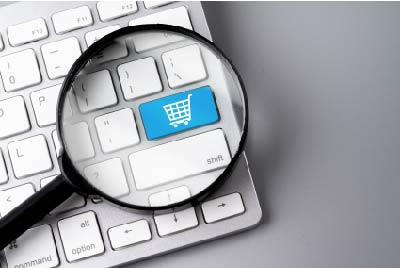 Image of the enter* key having the shopping cart icon, below a magnifying glass signifying Retail and E-commerce